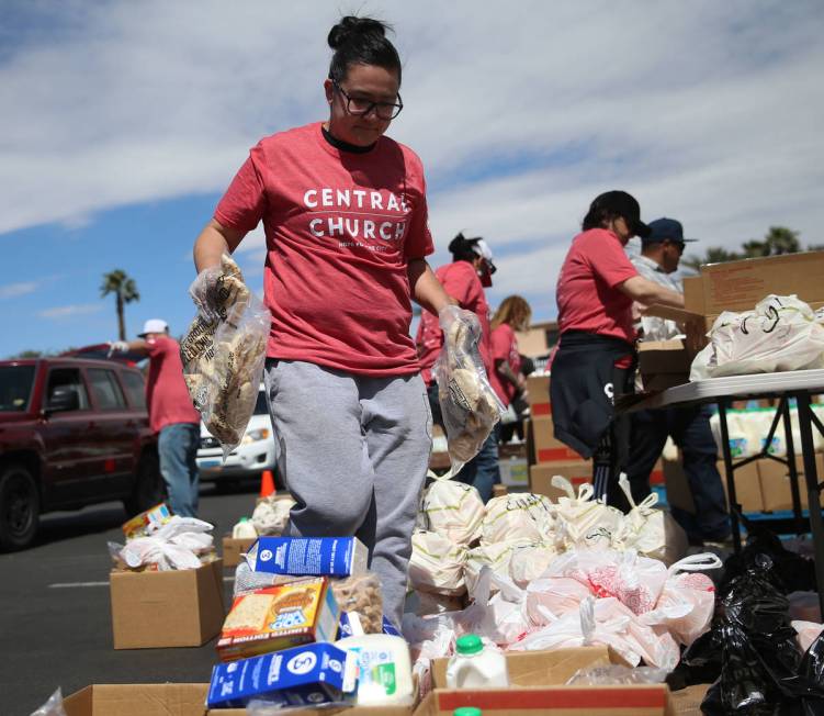 Three Square Food Bank volunteer Courtney Ford organizes boxes of food to give out at Palace St ...