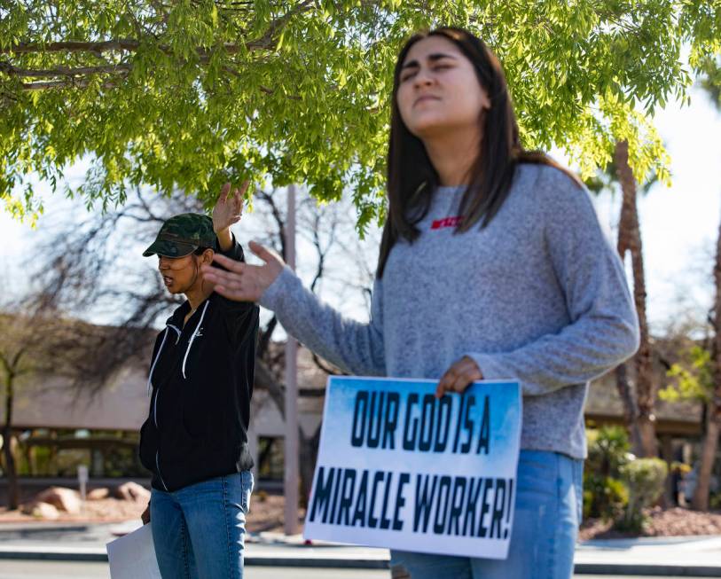 Crystal Espinoza, left, and Dariahne Navarro, 16, right, pray with family and friends for Adria ...