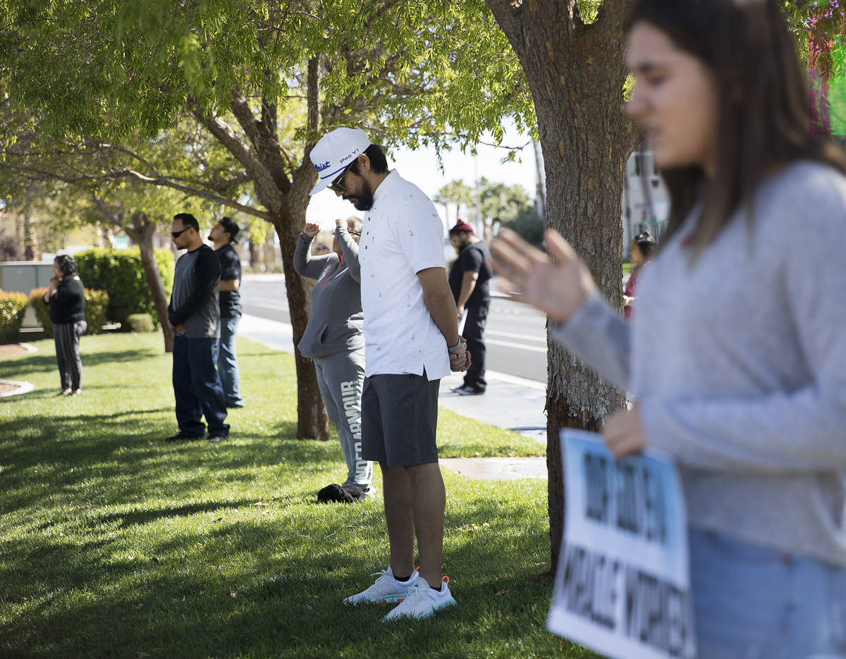 Haz Leon, center, prays with family and friends for his friend Adriana Huh who is in the hospit ...