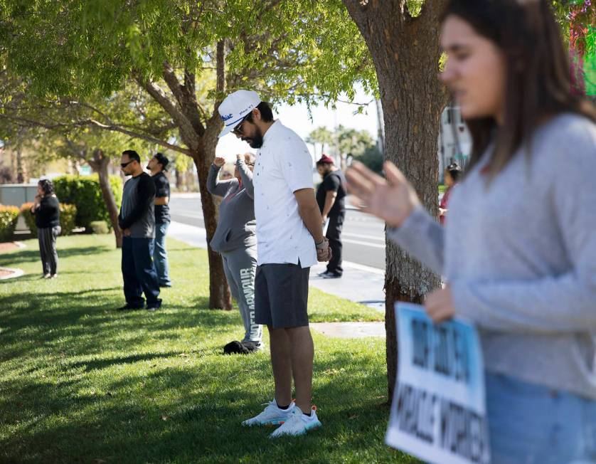 Haz Leon, center, prays with family and friends for his friend Adriana Huh who is in the hospit ...