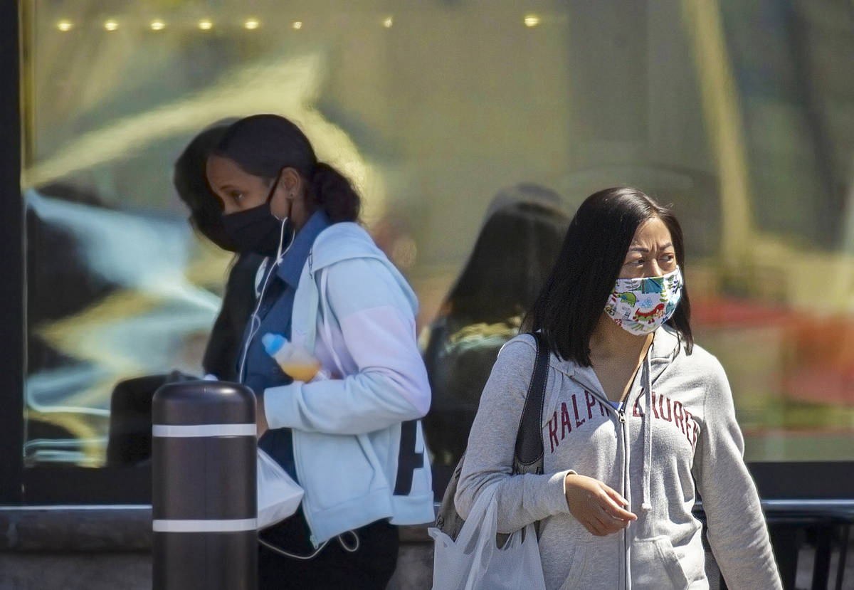 Shoppers wear protective masks outside Albertsons at North Hualapai Way in the northwest valley ...