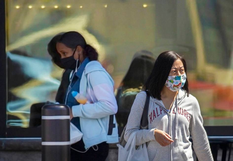 Shoppers wear protective masks outside Albertsons at North Hualapai Way in the northwest valley ...