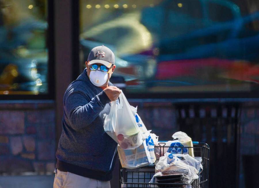 Shoppers wear protective masks outside Albertsons at North Hualapai Way in the northwest valley ...