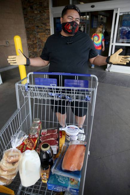 Sheffield Abella, 50, of Las Vegas, dons a mask while shopping at Sam's Club in southwest Las V ...