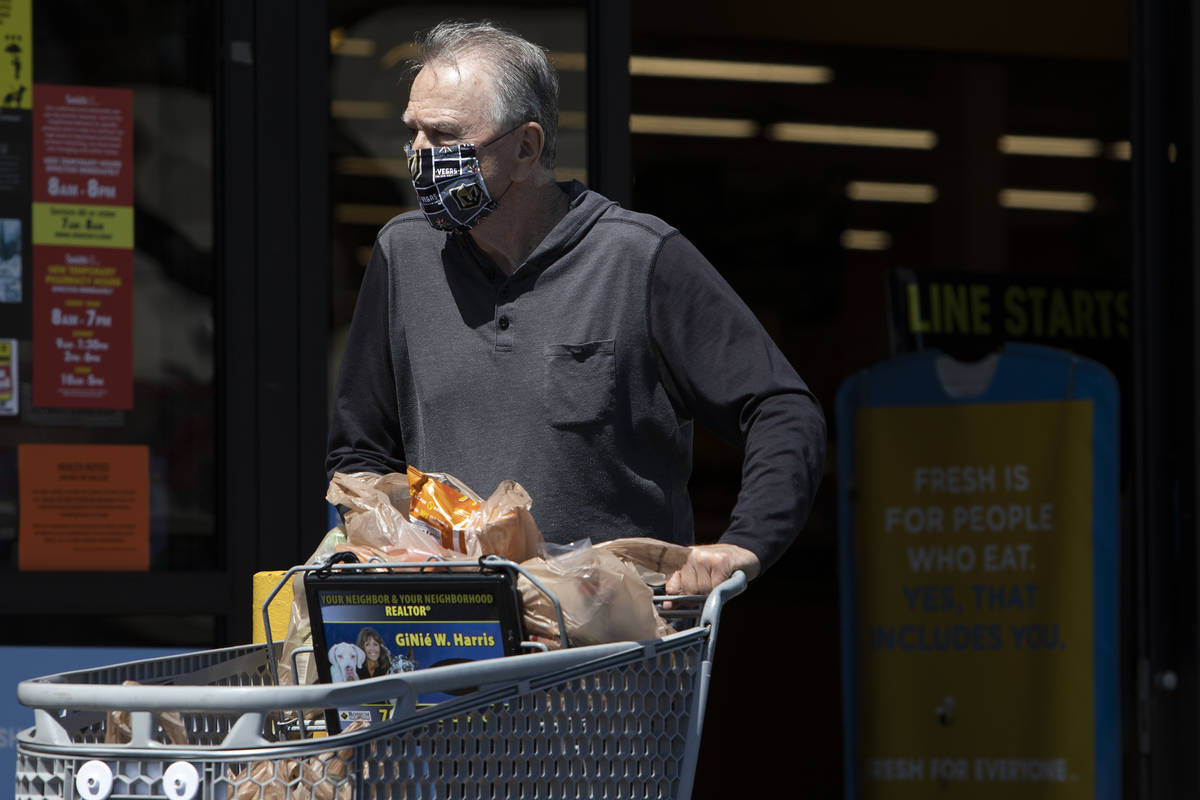 Michael McGowan wears a mask made out of Vegas Golden Knights fabric as he exits the Smith's Fo ...