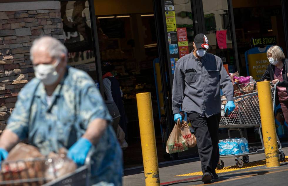 Masked shoppers exit Smith's Food and Drug on South Rancho Drive on Friday, April 3, 2020, in L ...