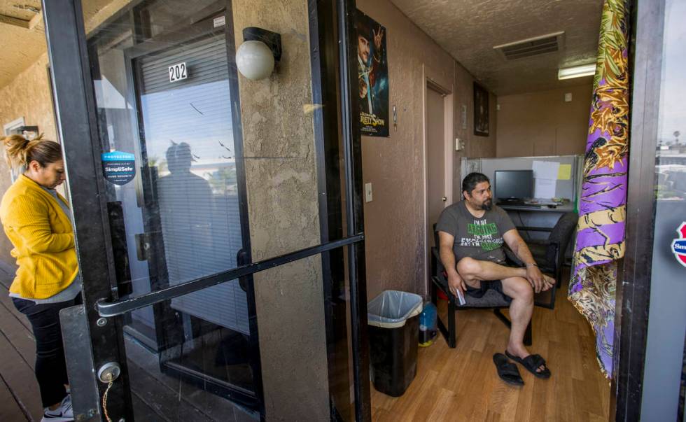 Jeremy Ferreira, right, sits a small office space he and his family of five are temporarily liv ...