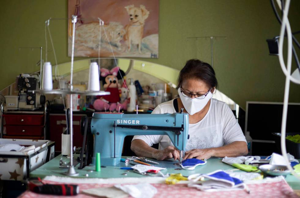 Alia Berry sews masks, meant to protect people from COVID-19, at her home on Friday, April 3, 2 ...