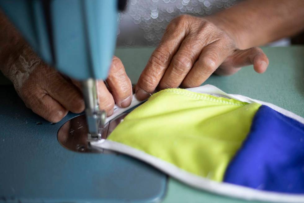 Alia Berry sews masks, meant to protect people from COVID-19, at her home on Friday, April 3, 2 ...