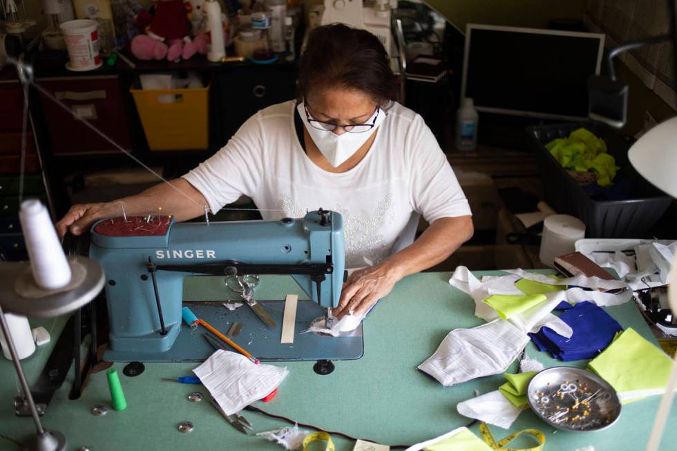 Alia Berry sews masks, meant to protect people from COVID-19, at her home on Friday, April 3, 2 ...