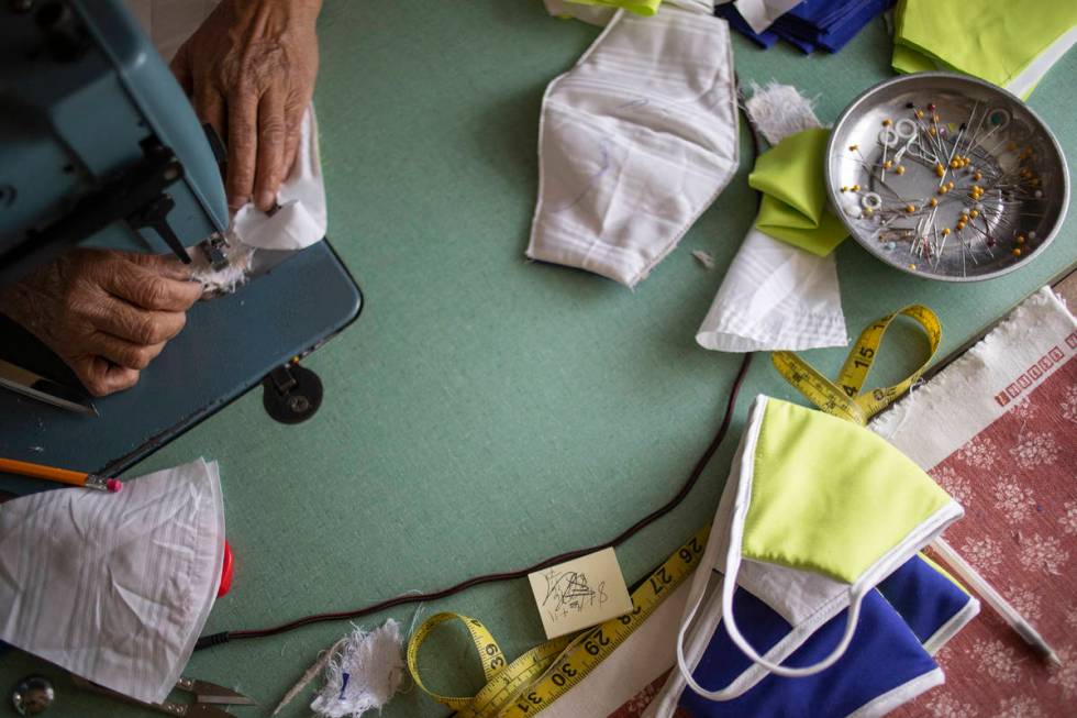 Alia Berry sews masks, meant to protect people from COVID-19, at her home on Friday, April 3, 2 ...