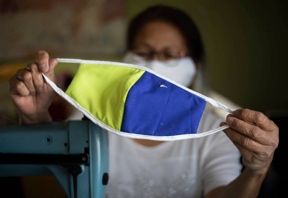 Alia Berry holds up one of her hand sewn masks at her home on Friday, April 3, 2020, in Las Veg ...