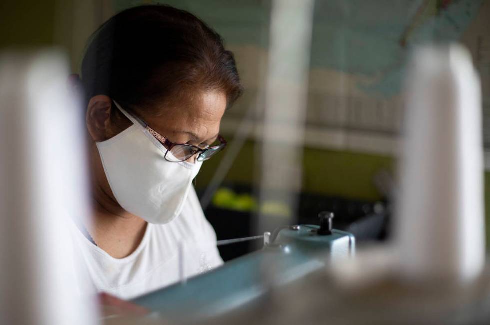 Alia Berry sews masks, meant to protect people from COVID-19, at her home on Friday, April 3, 2 ...