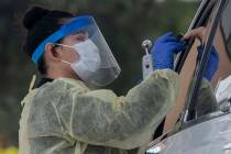 A UNLV medicine medical professional conducts a curbside test on a patient experiencing coronav ...