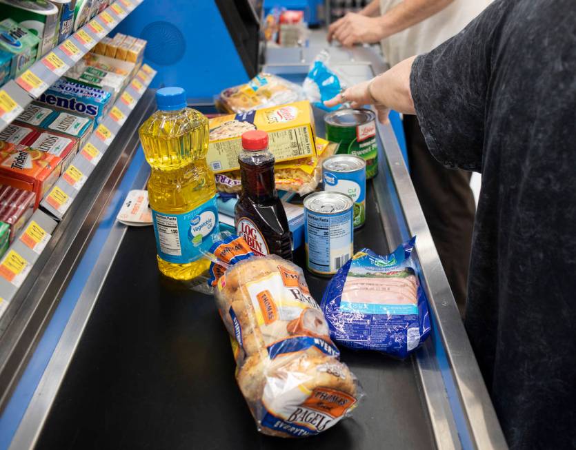 Debbie Holmgren unloads the cart as Todd Henke scans their haul from Walmart on Saturday, April ...