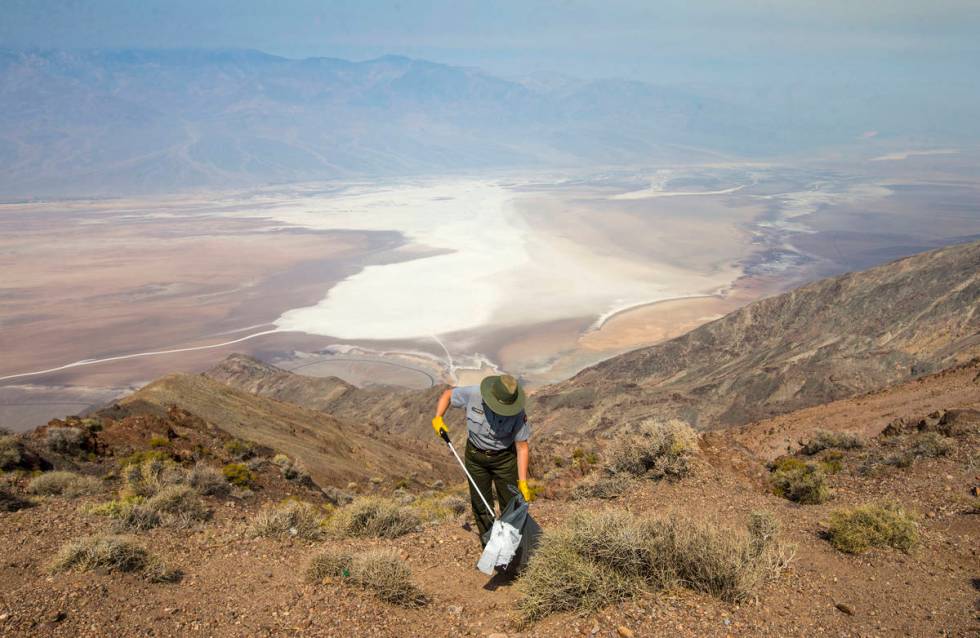 In this Aug. 7, 2018, file photo, Death Valley National Park custodian Terry Eddington picks up ...