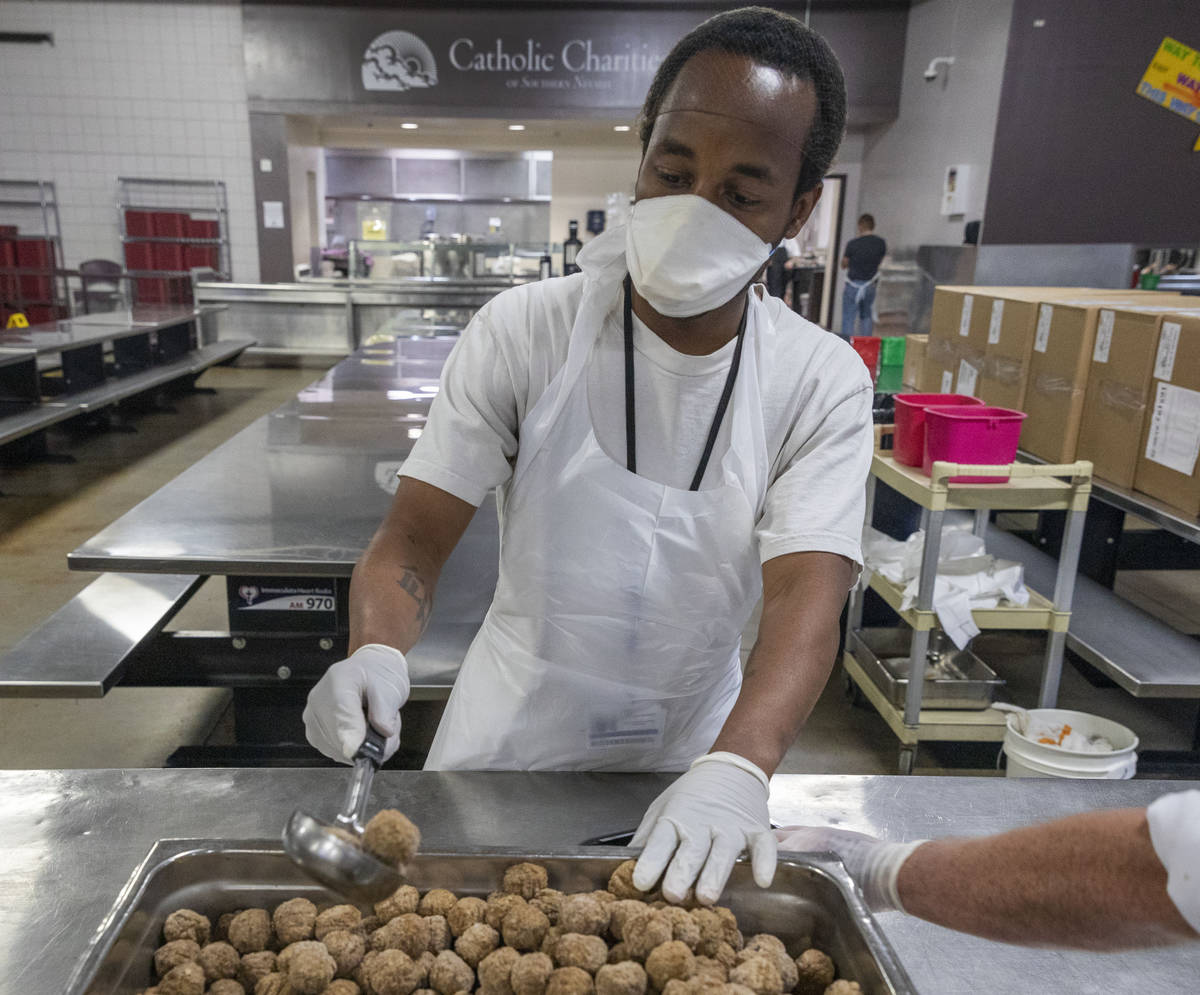 Kevin Terry helps package a dish for Meals on Wheels, at Catholic Charities of Southern Nevada ...