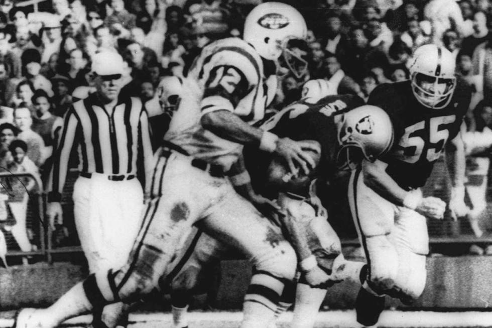 New York Jets' quarterback Joe Namath (12) sweeps around the right side past Oakland defenders ...