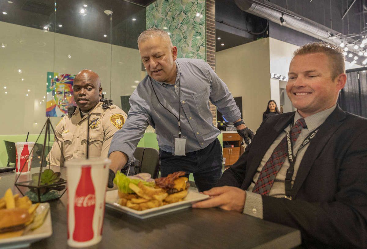 Food and beverage director Hank Serrano, center, serves Sgt. Albert Reeder, left, and Lt. Alan ...