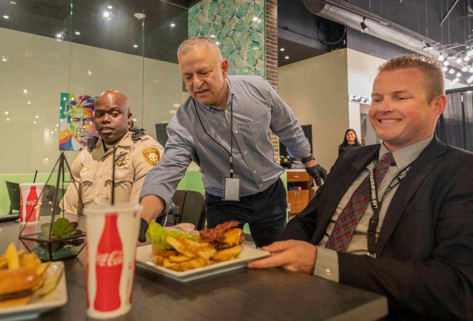 Food and beverage director Hank Serrano, center, serves Sgt. Albert Reeder, left, and Lt. Alan ...