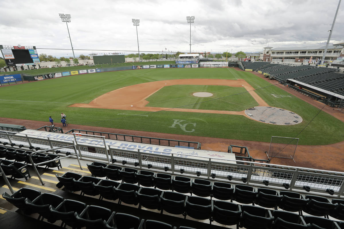 A broadcast crew finishes-up near the Kansas City Royals' dugout in an otherwise empty ballpark ...