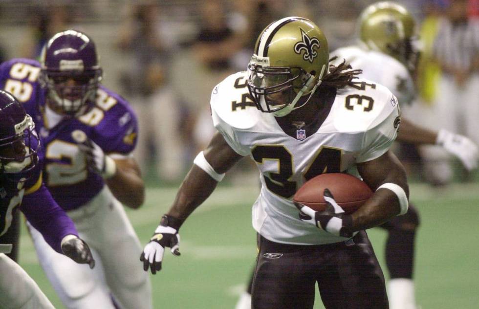 New Orleans Saints running back Ricky Williams (34) runs past Minnesota Vikings defenders durin ...