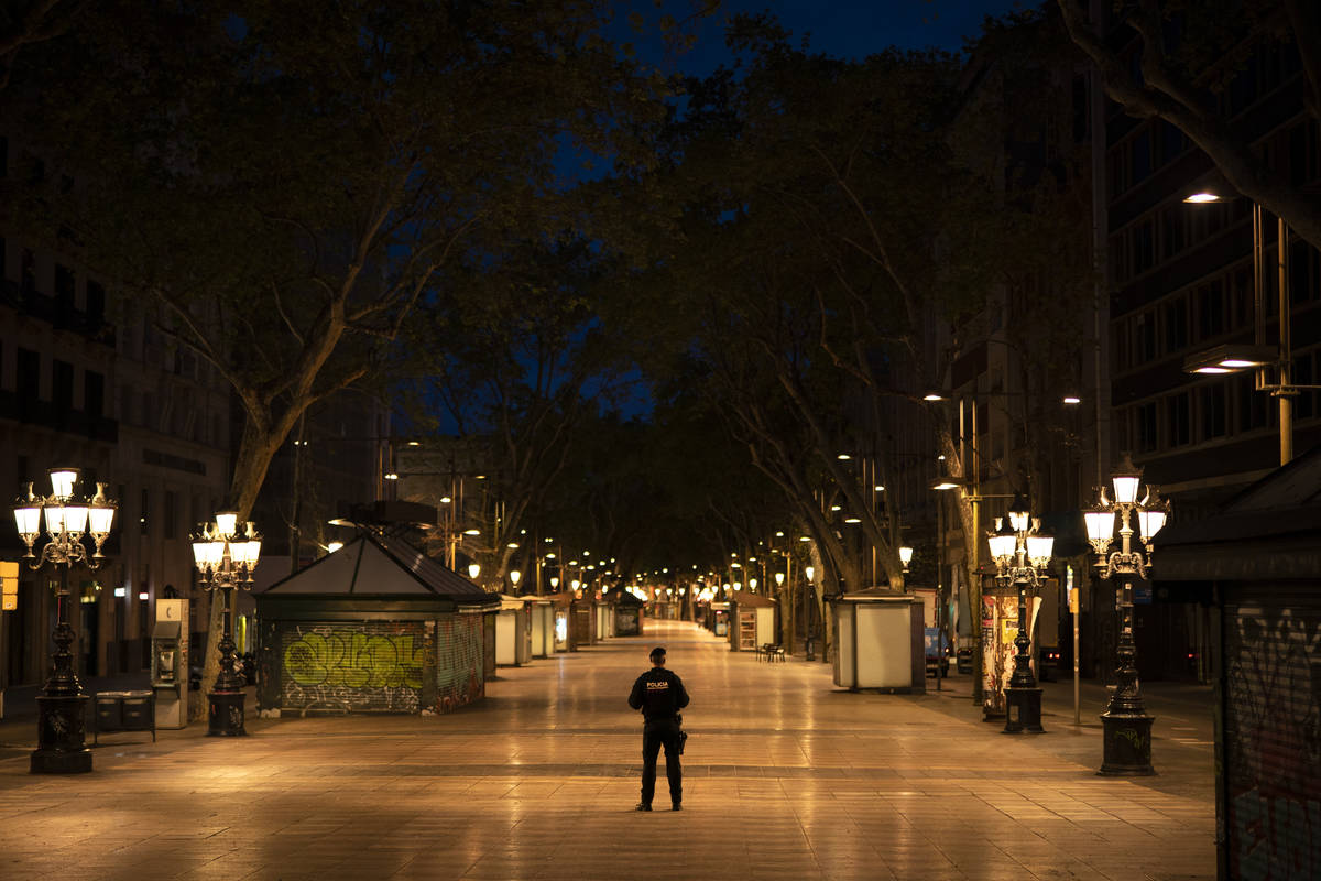 A Catalan police officer stands in the middle of La Ramblas street devoid of the usual crowds d ...