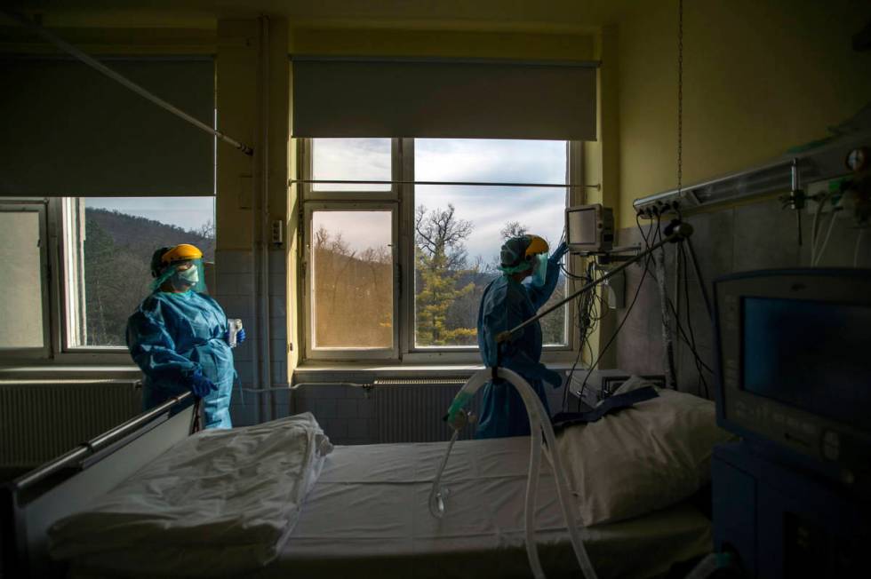 FILE - In this March 24, 2020, file photo, medical staff members check a ventilator in protecti ...