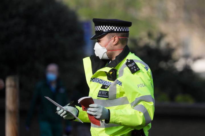 A British police officer wears a 3M face mask, with few police officers in Britain seen wearing ...