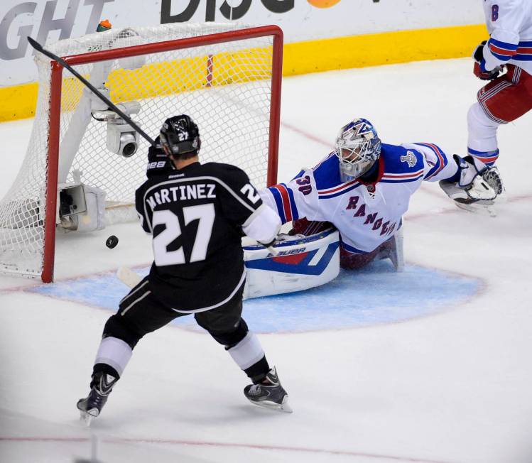 Los Angeles Kings defenseman Alec Martinez, left, scorees the winning goal past New York Ranger ...