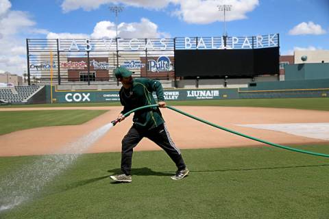 Groundskeeper Logan Mace sprays water on the field at the Las Vegas Ballpark in Las Vegas, Thur ...