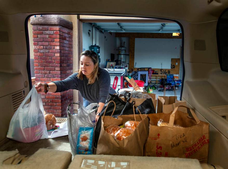 Kat Morris fills the back of her car with food and supplies for another donation drop with the ...