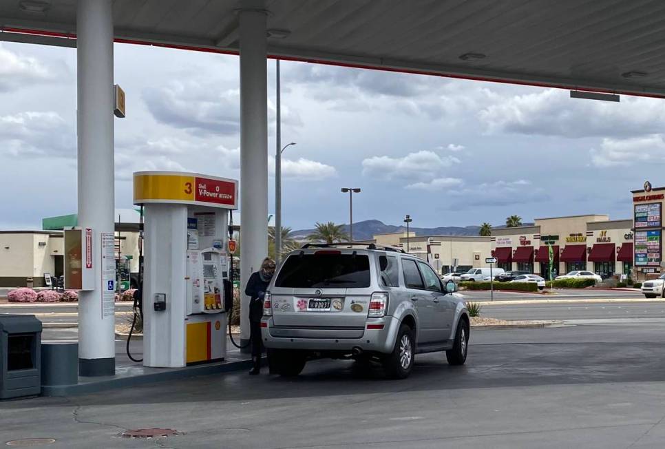 A woman in a Raiders face masks pumps gas at the Shell Station on south Eastern near the 215 Be ...