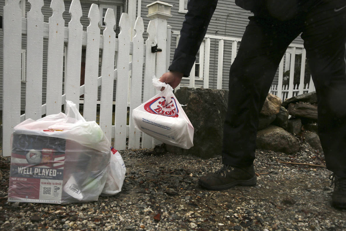 Instacart worker Arthur Berte leaves groceries at the gate of a home in East Derry, N.H., Frida ...