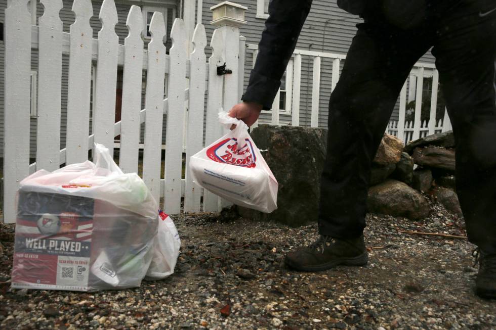 Instacart worker Arthur Berte leaves groceries at the gate of a home in East Derry, N.H., Frida ...