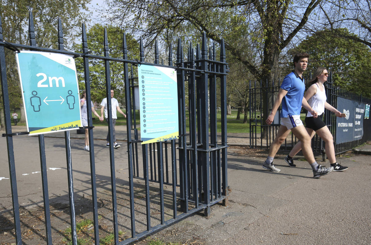 Signs on the gates reminding people to 'social-distance' at Victoria Park, in east London, afte ...