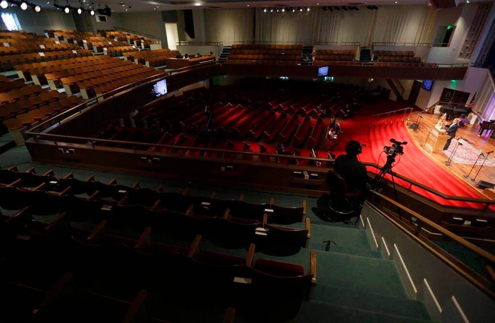 Pastor Les Hollon, right, holds an online Easter service at Trinity Baptist Church with a small ...