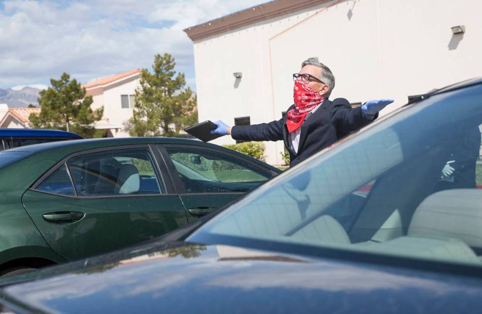 Pastor Paul Marc Goulet walks among cars as he leads an Easter service in the parking lot at In ...