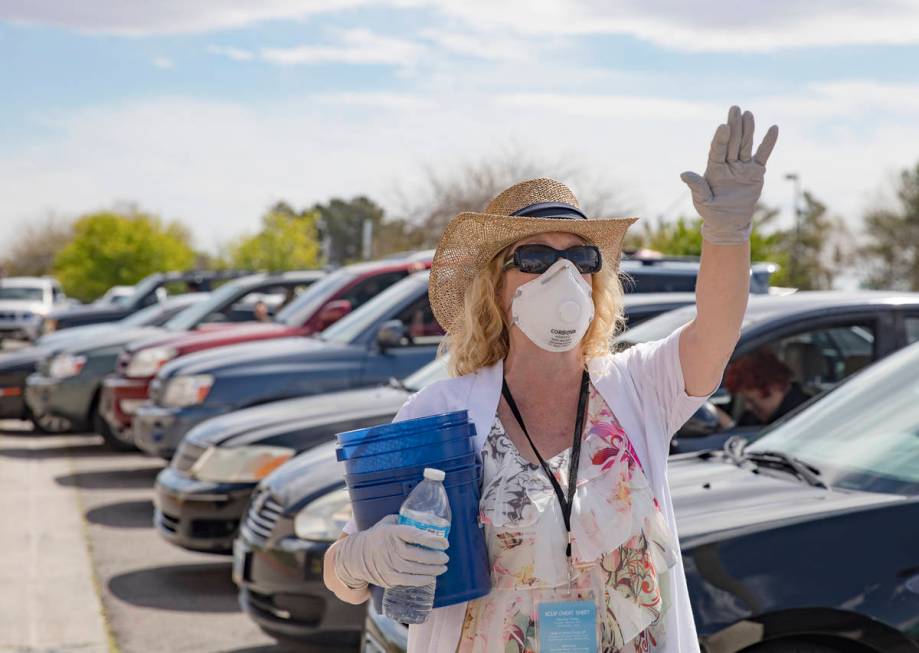 Usher Deborah Withrow worships alongside guests in their cars at an Easter service in the parki ...