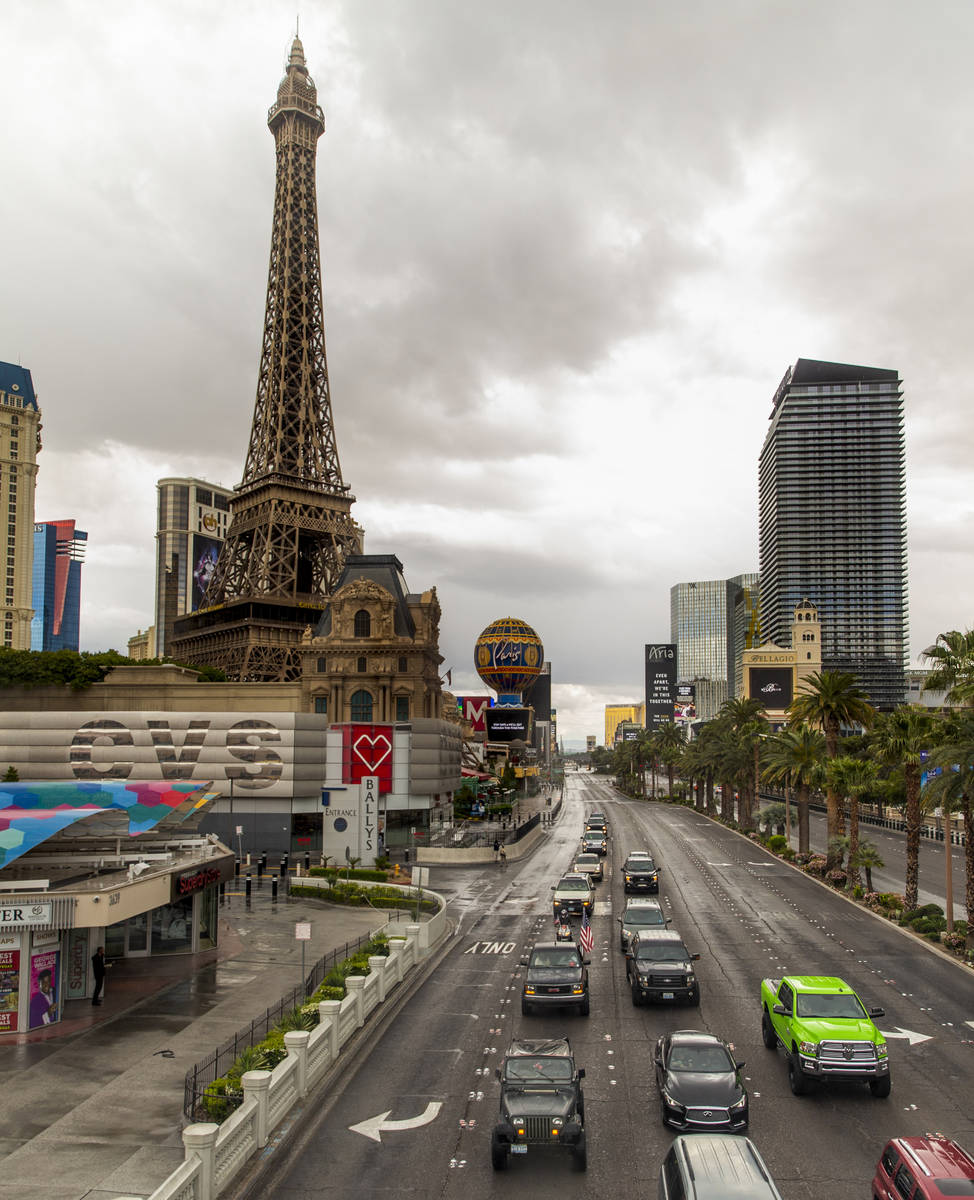 Some participants fly American flags as vehicles make their way up the Las Vegas Strip during t ...