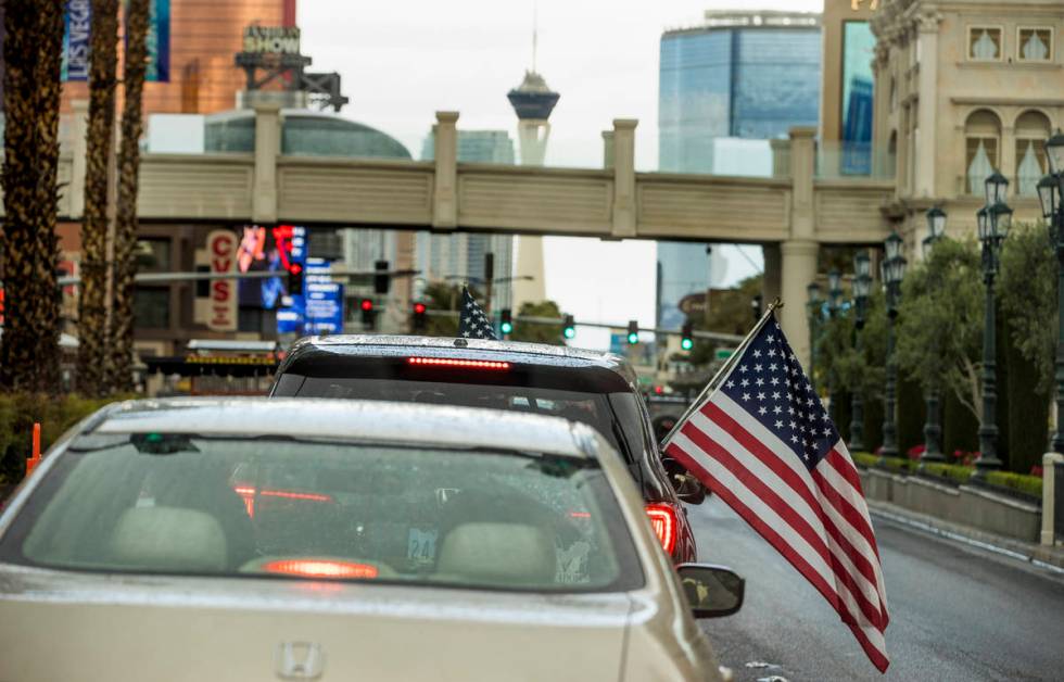 Some participants fly American flags as vehicles make their way up the Las Vegas Strip during t ...