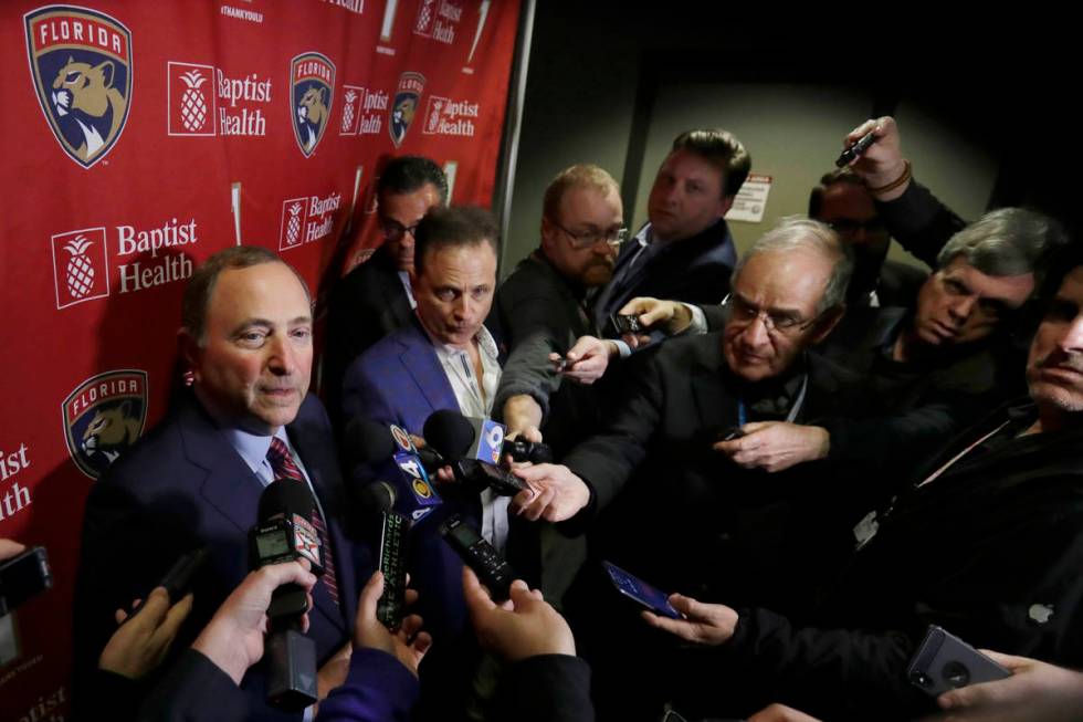 National Hockey League Commissioner Gary Bettman, left, speaks to members of the media , Saturd ...