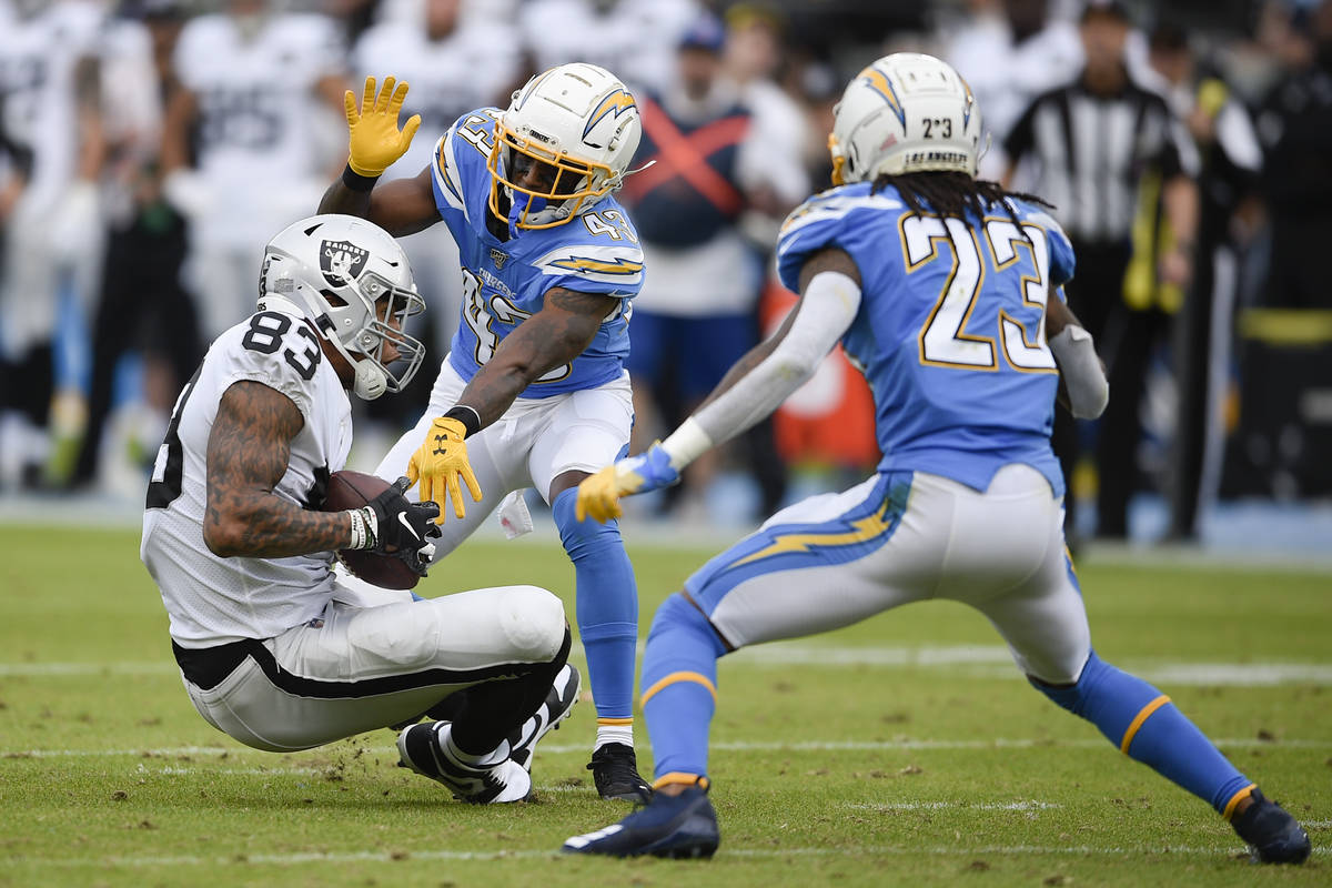 Oakland Raiders tight end Darren Waller, left, catches a ball while Los Angeles Chargers corner ...