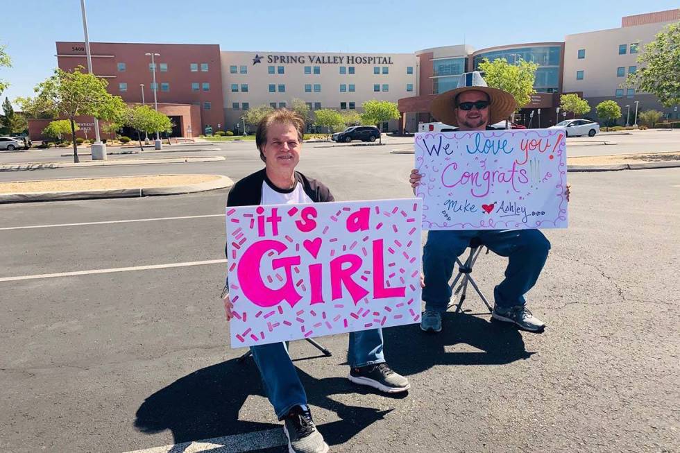 Gary Brola, left, and his stepson Mike Carney hold signs in the parking lot of Spring Valley Ho ...