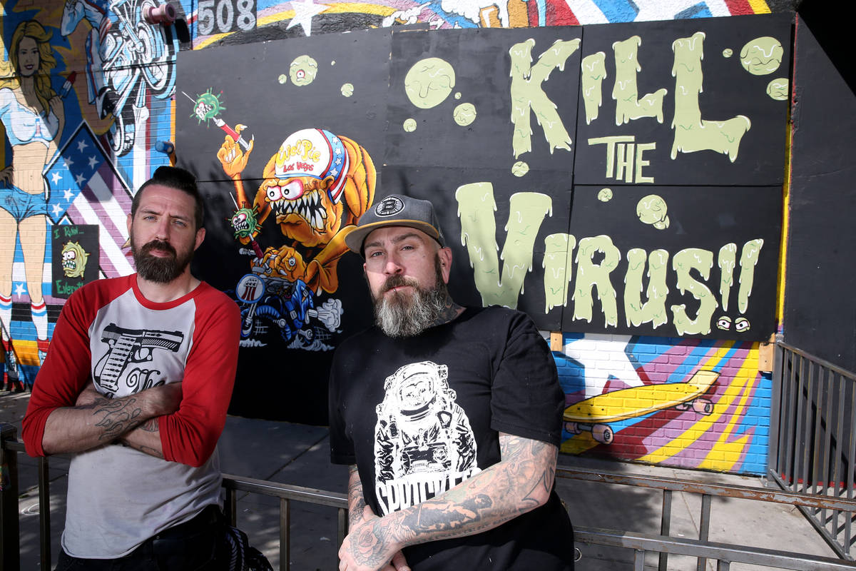 Jeff Lewis, left, and Dustin Hoots with their coronavirus mural on the boarded up windows of Ev ...