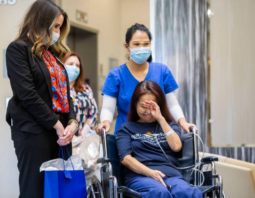 MountainView Hospital nurse Bessy Angue, bottom/right, wipes tears from her eyes as she's greet ...