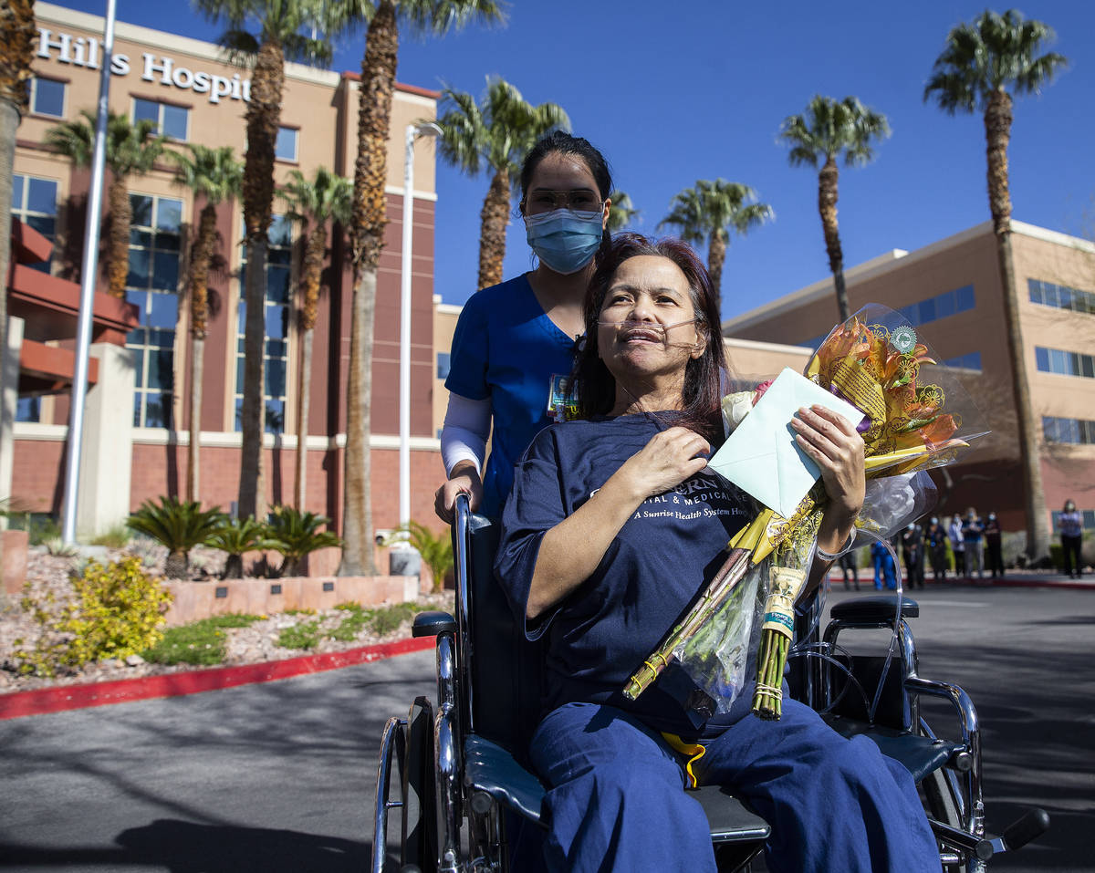 MountainView Hospital nurse Bessy Angue, bottom/right, is wheeled out of Southern Hills Hospita ...