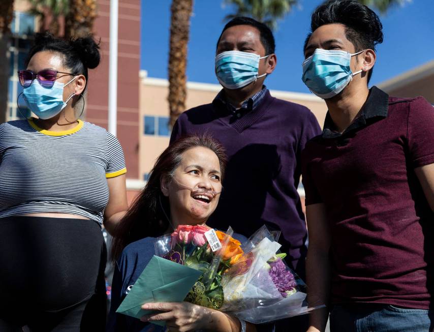 MountainView Hospital nurse Bessy Angue, middle, is greeted by friends, family and medical staf ...