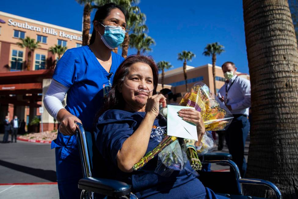 MountainView Hospital nurse Bessy Angue, bottom/right, is wheeled out of Southern Hills Hospita ...