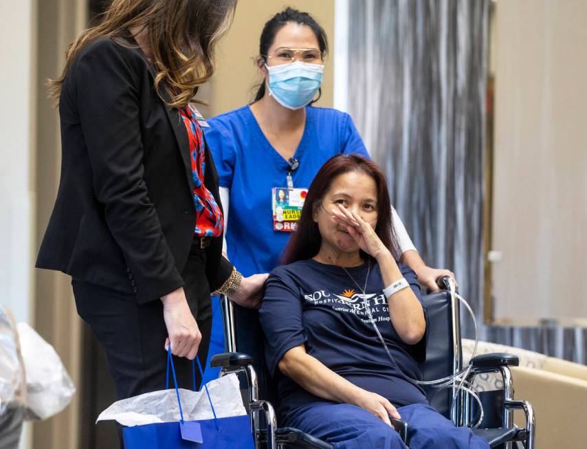 MountainView Hospital nurse Bessy Angue, bottom/right, wipes tears from her eyes as she's greet ...